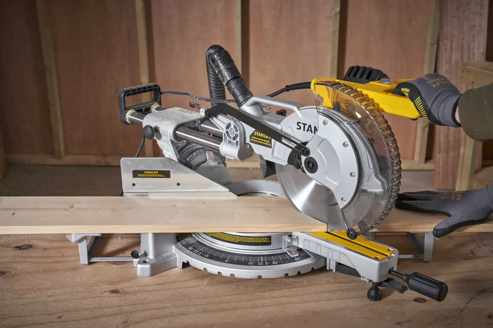 Fotografia della troncatrice STANLEY SM1800 che taglia legno, vista ravvicinata in officina.