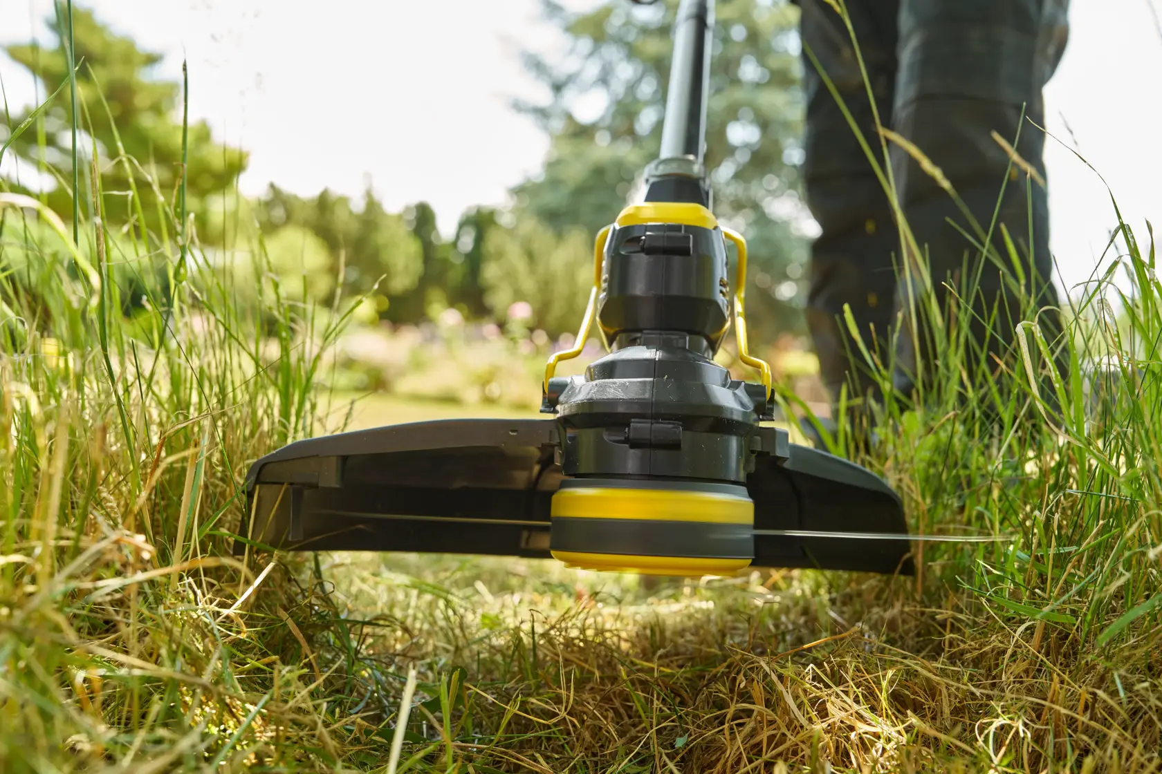 STANLEY STCST933M1 coupe-bordures en gros plan, utilisé sur pelouse avec herbe verte, photographie en extérieur.