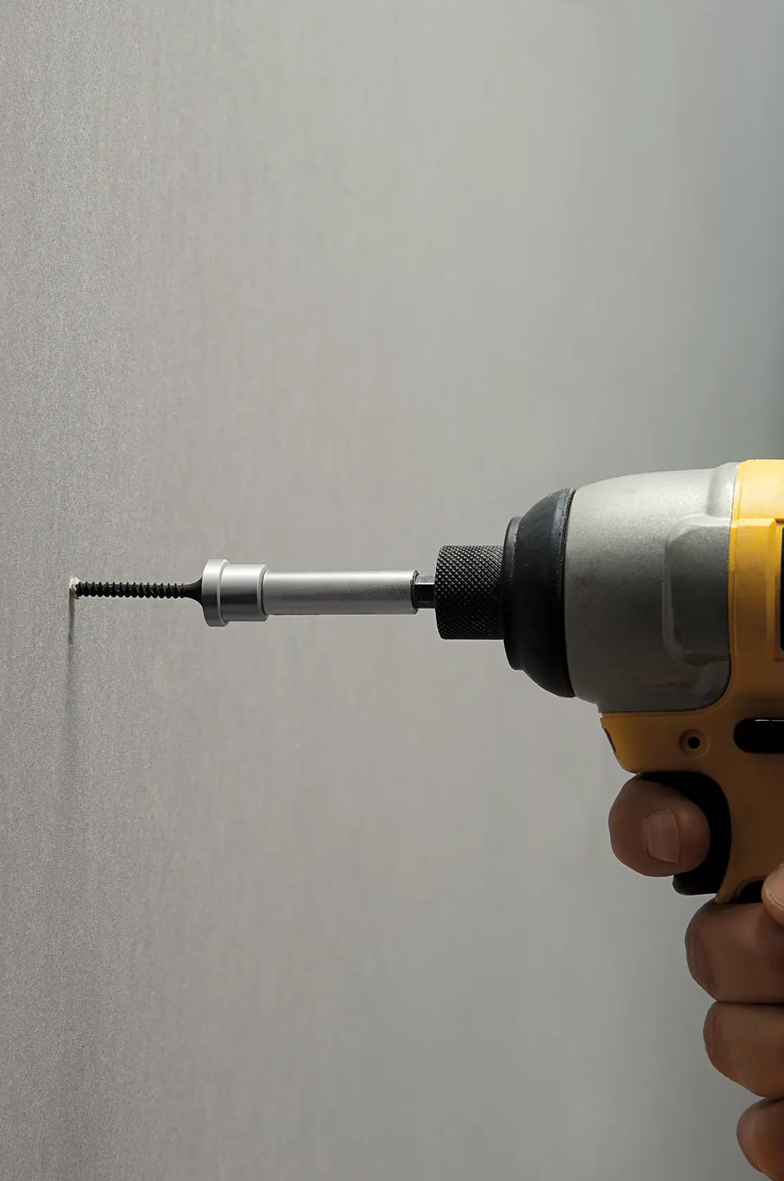 STANLEY STHT0-16137 Schraubendreher-Bit in Bohrmaschine schraubt Schraube in Wand, Seitenansicht.
