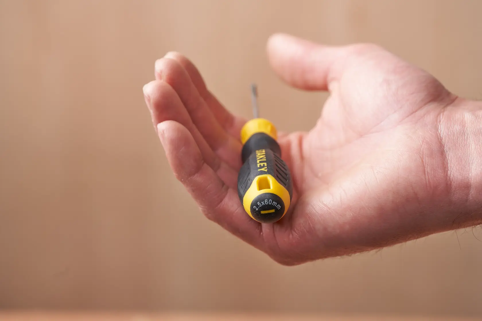 Photo of STANLEY STHT16151-0 screwdriver with yellow and black handle, held in a person's hand.