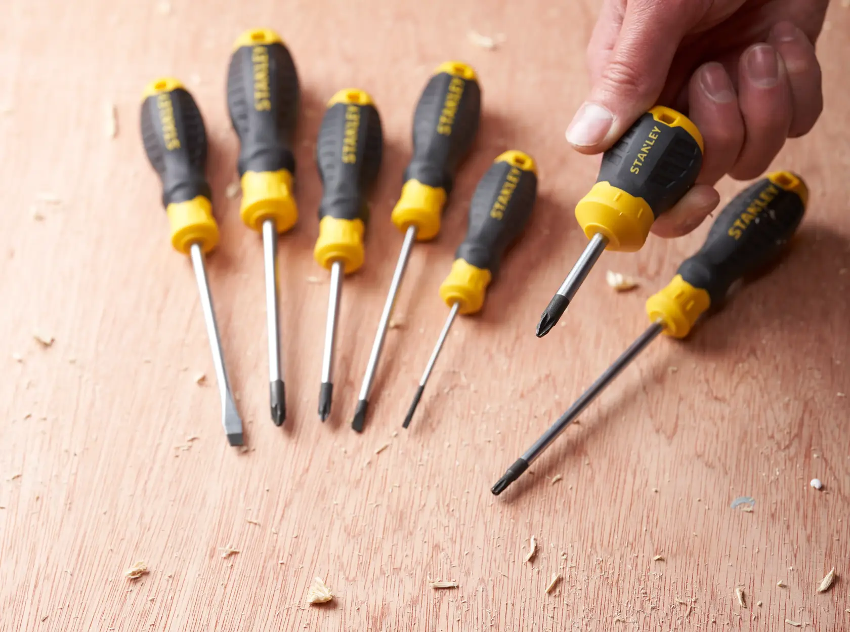 STANLEY STHT16196-0 screwdriver set with black and yellow handles, shown on a wooden surface.