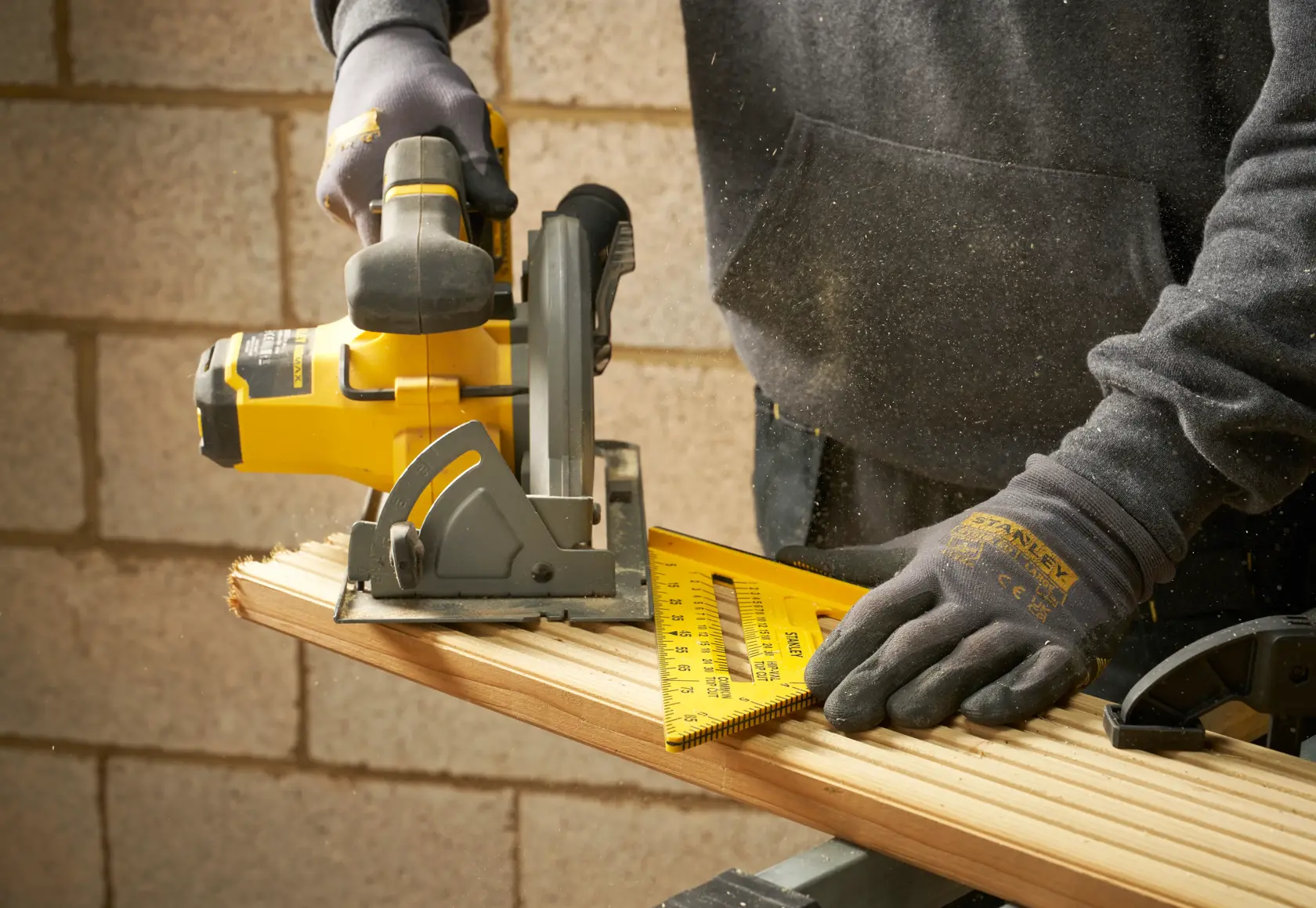 Photographie de la règle carrée STANLEY STHT46010-0 utilisée en menuiserie, règle jaune sur le bois.