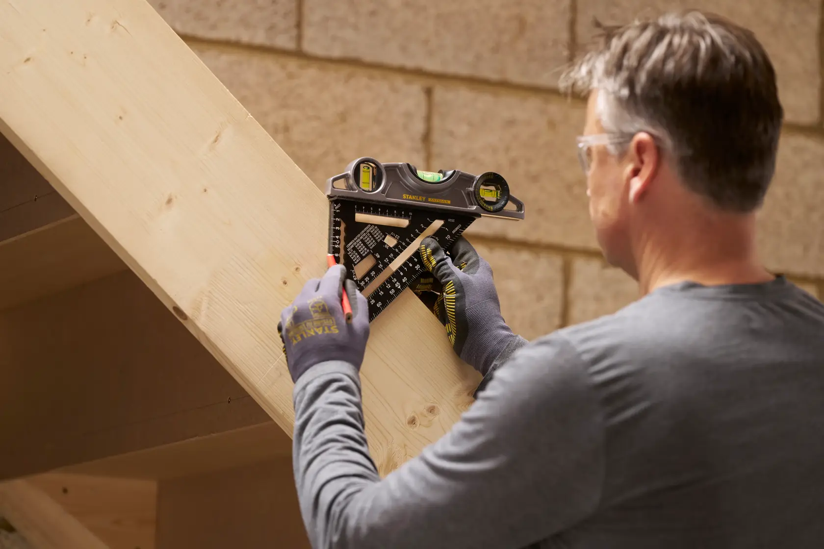 Squadra combinata STANLEY STHT46101-0 usata da una persona per segnare linee su una trave di legno.