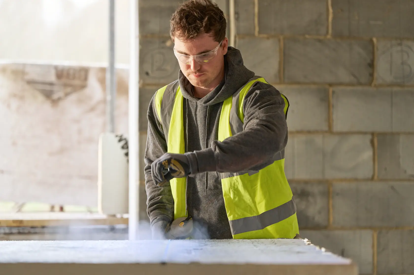 Foto di persona con gilet ad alta visibilità STANLEY SKU STHT47110-0 in cantiere, vista frontale.