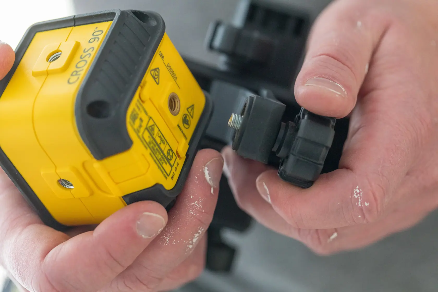 STANLEY STHT77592-1 Kreuzlinien-Laser auf Wand montiert, Seitenansicht, gelbes und schwarzes Gehäuse.