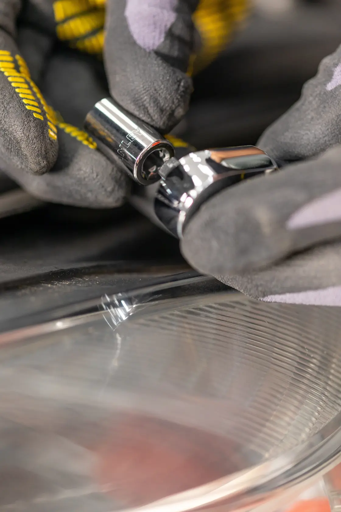 STANLEY STMT82828-1 socket tool held by gloved hand, close-up with reflective surface below.