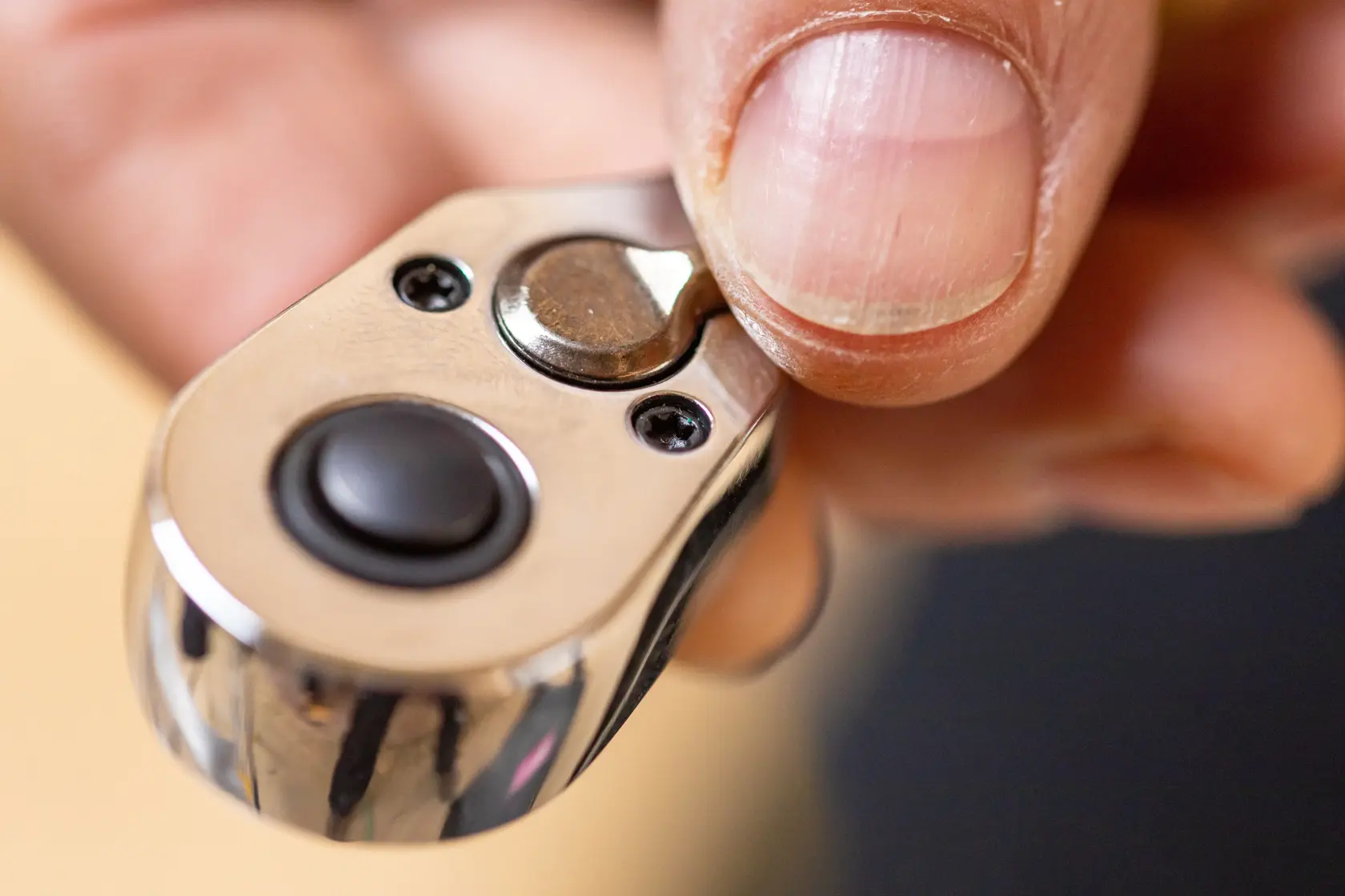 Photo of STANLEY STMT82828-1 ratchet head close-up with thumb pressing quick-release button.