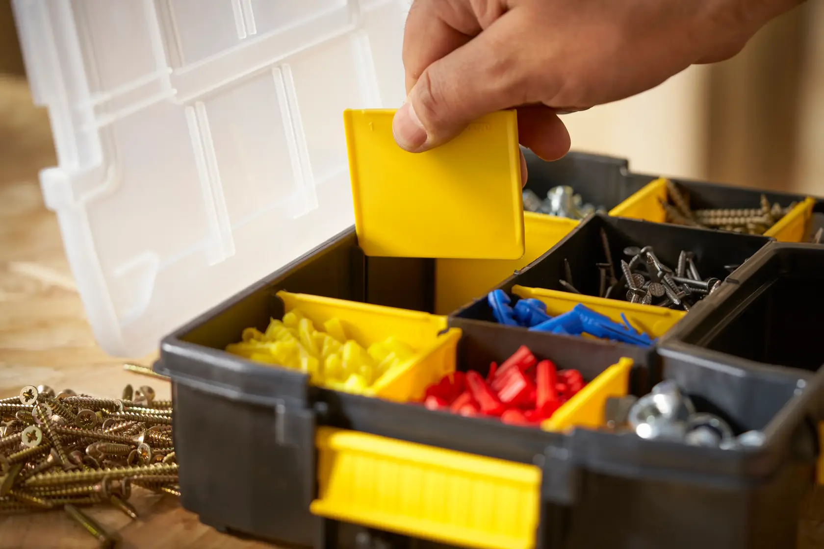 STANLEY STST1-70720 organizer box with yellow, red, blue compartments, hand lifting divider, front angle.
