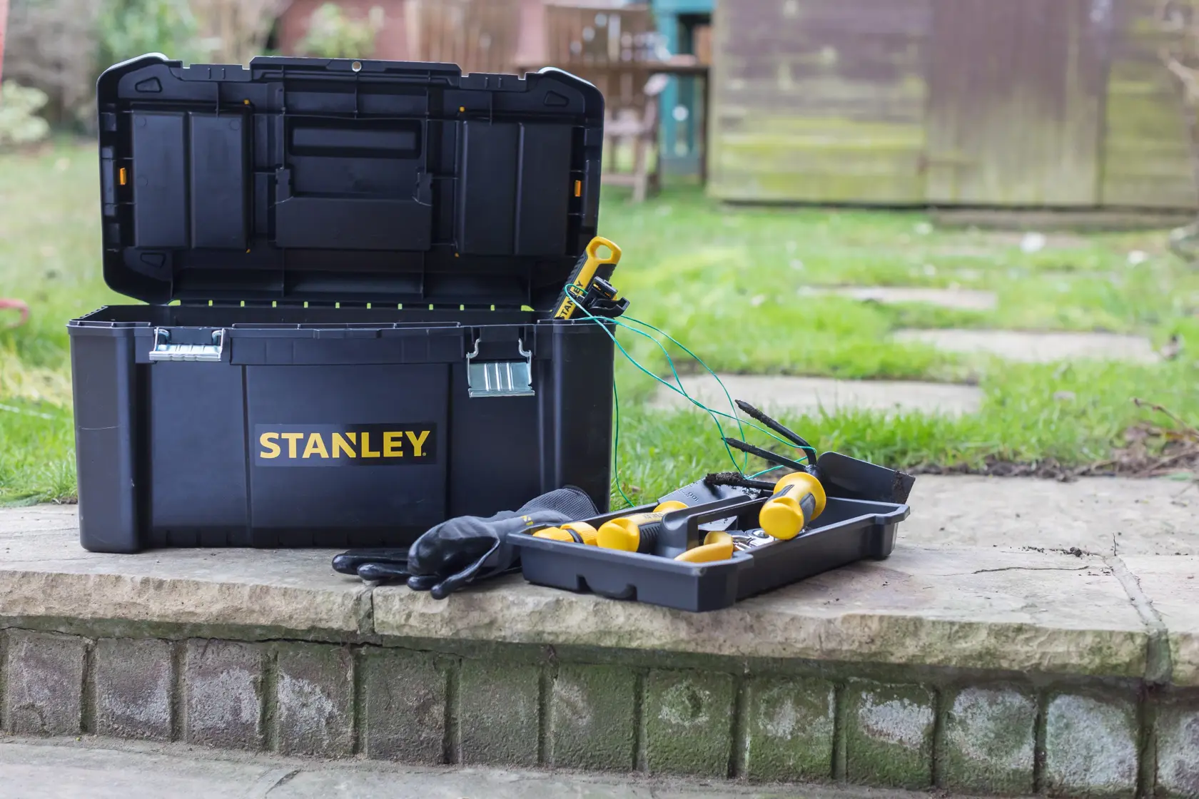 STANLEY STST1-75521, STST1-75521-KR toolbox open outdoors with tray, tools, and gloves, product photography.