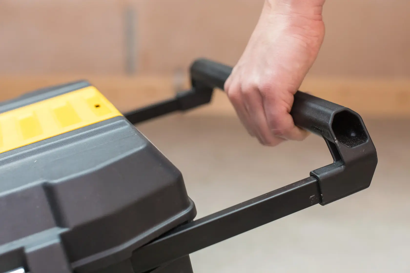 STANLEY STST1-80150 boîte à outils gros plan montrant poignée noire tenue, couvercle jaune partiellement visible.