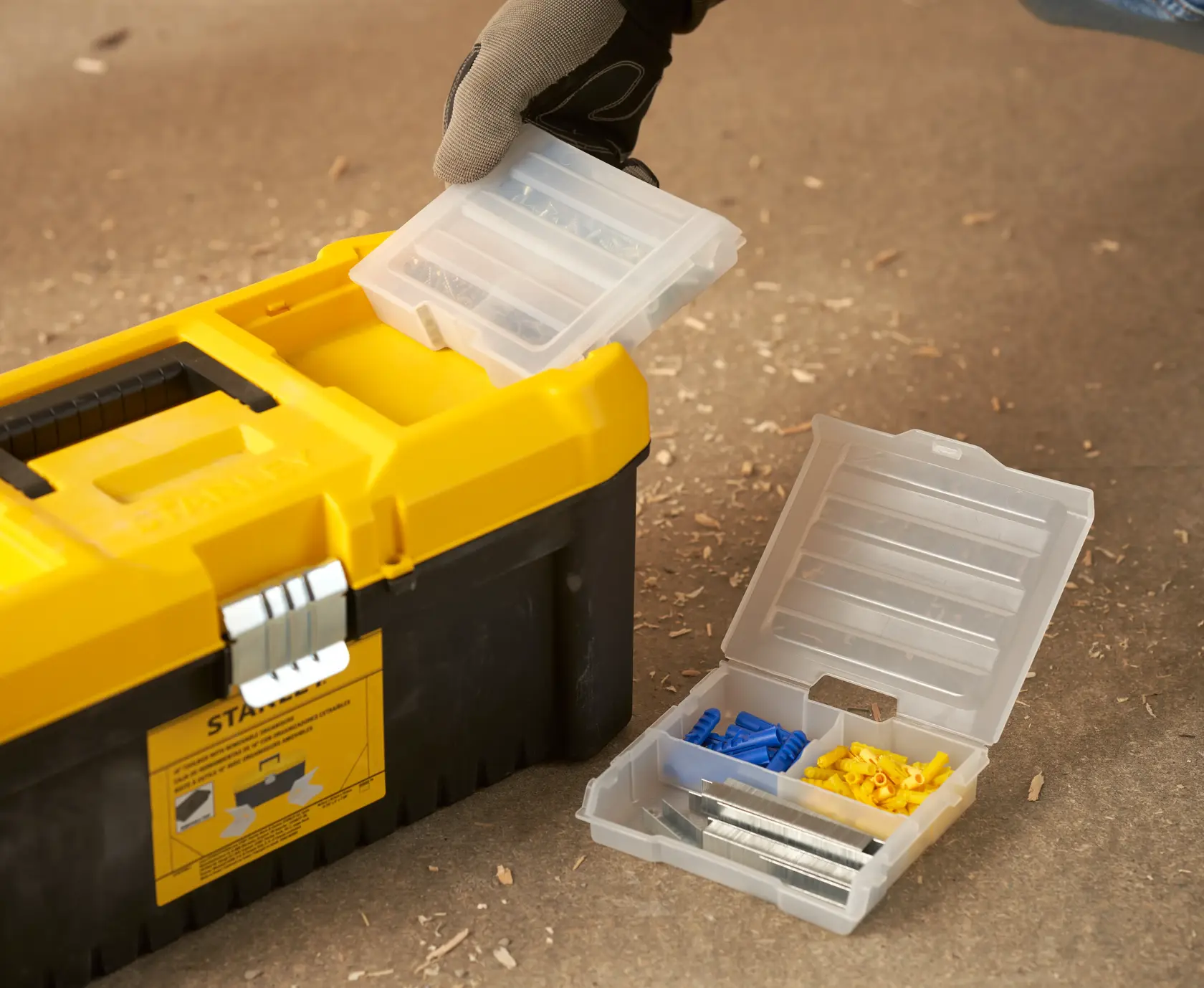 STANLEY STST75785-1 toolbox with open plastic organizer containing screws and wall plugs, close-up.