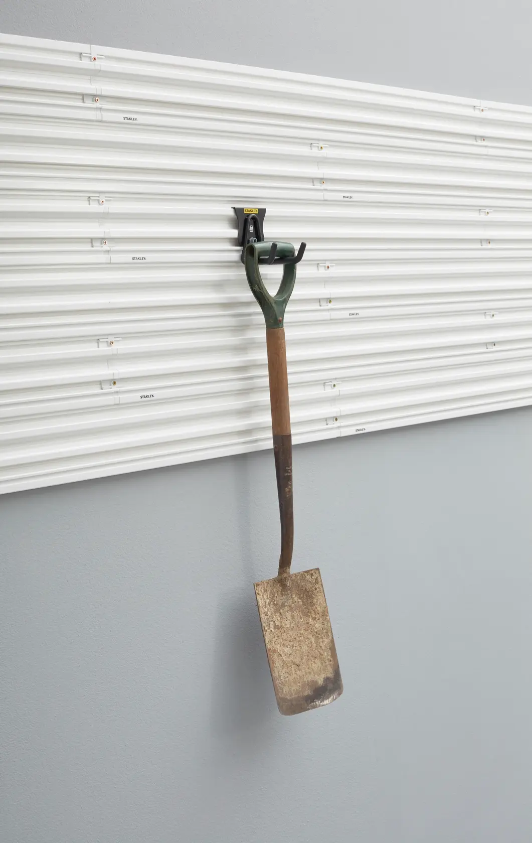 Foto des STANLEY STST82607-1 Wandpaneels mit Metallgartenschaufel an Aufbewahrungshaken, Vorderansicht.