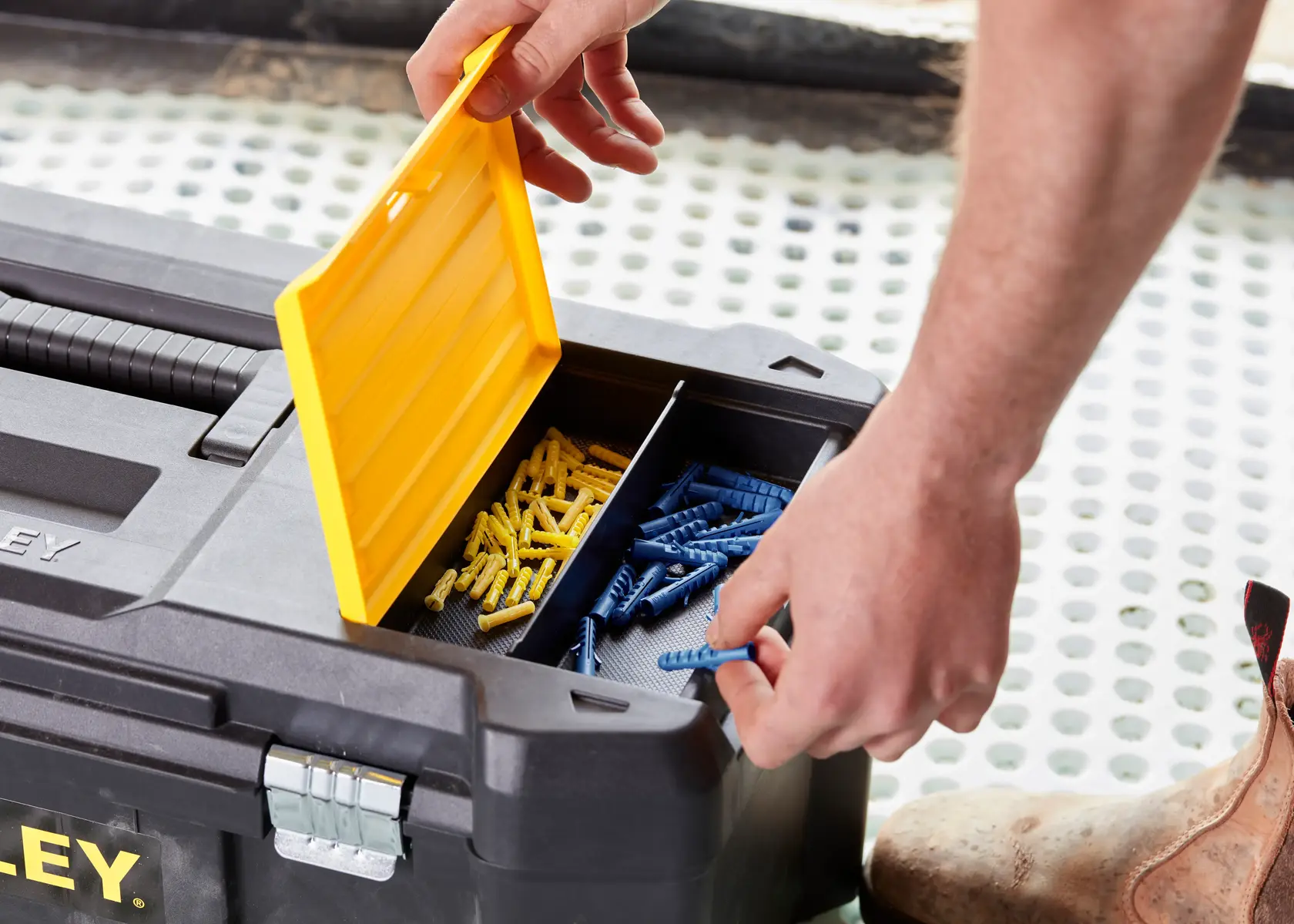 STANLEY STST82976-1 toolbox with open yellow lid, showing organized blue and yellow wall plugs inside.