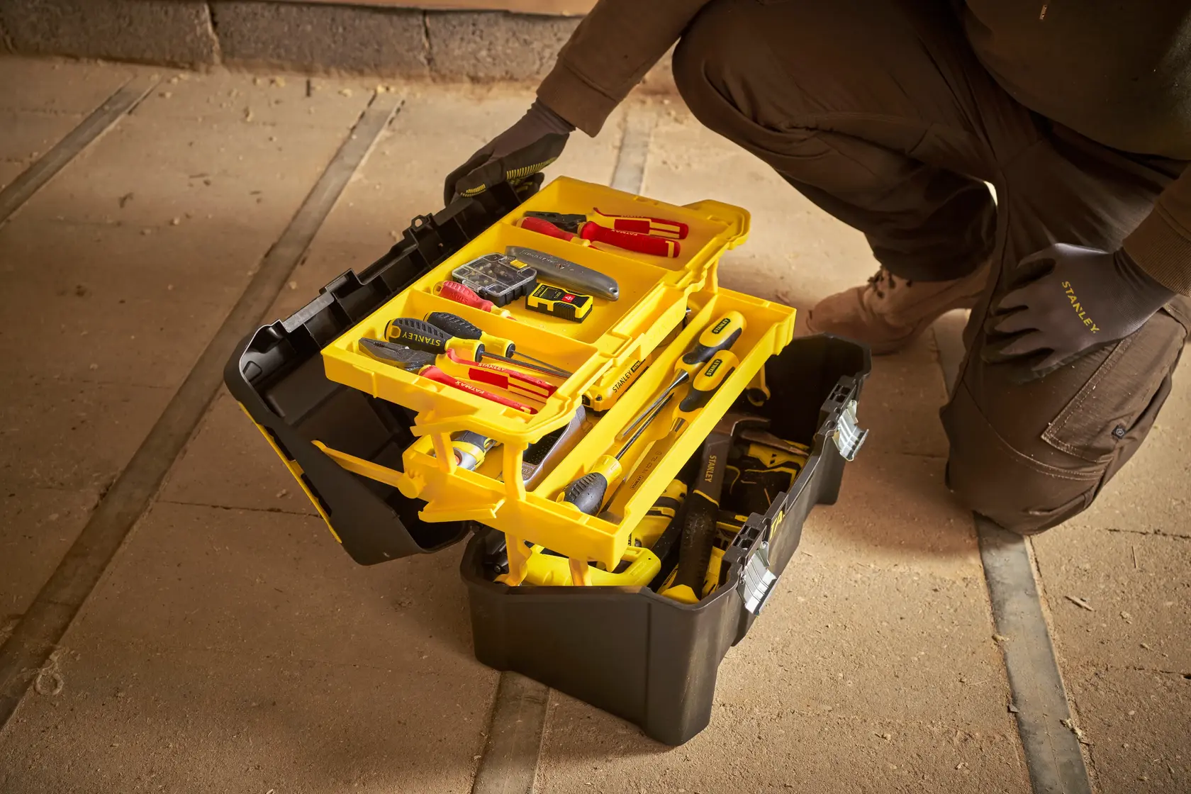 STANLEY STST83397-1 black and yellow toolbox with trays and tools, photographed open on workshop floor.