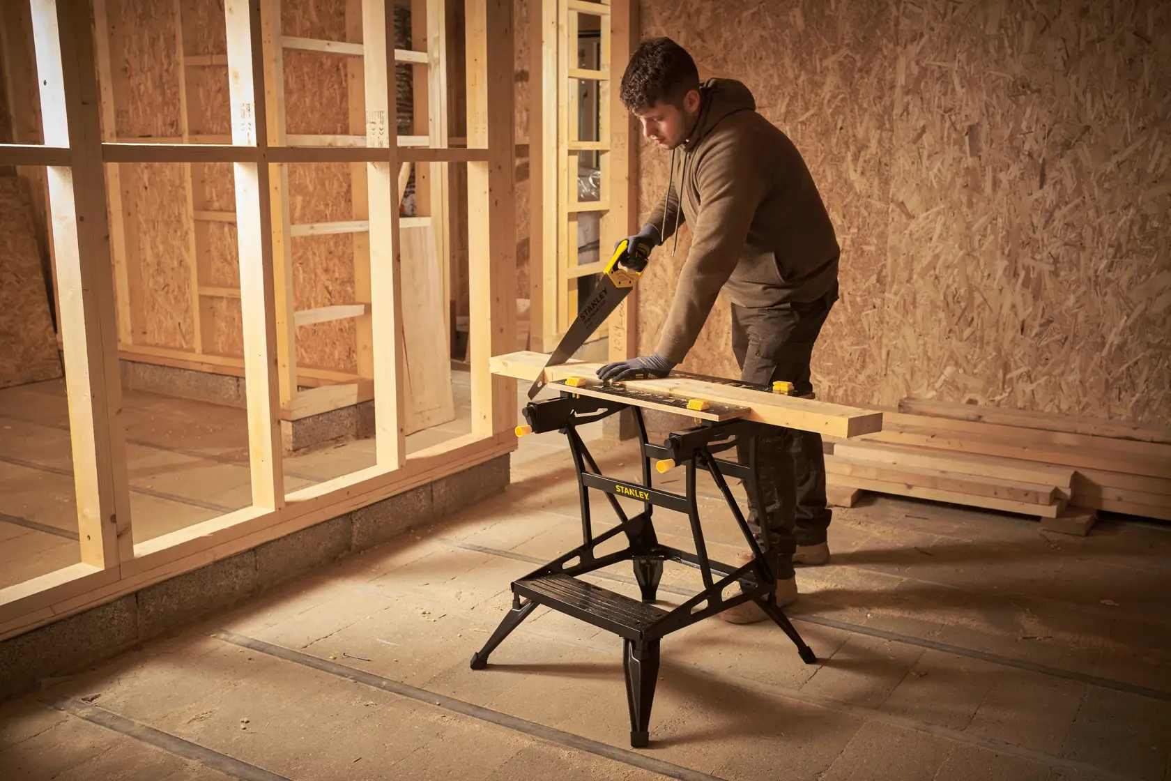 STANLEY STST83400-1 chevalet en utilisation, supportant une planche en chantier.
