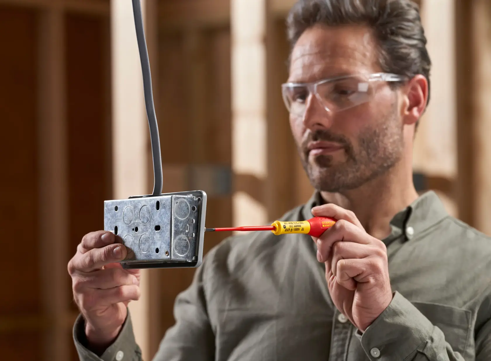 STANLEY XTHT0-62692 screwdriver used on metal electrical box, close-up, photography category.